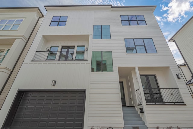 view of front of property featuring an attached garage and a balcony