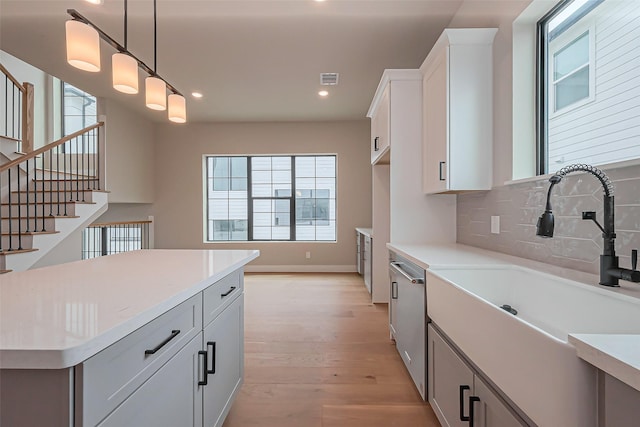 kitchen with a sink, dishwasher, and light countertops