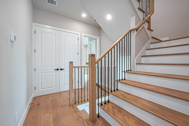 stairway featuring visible vents, recessed lighting, baseboards, and wood finished floors