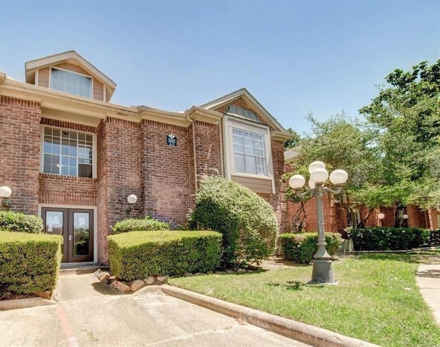 view of front of property featuring brick siding and a front yard