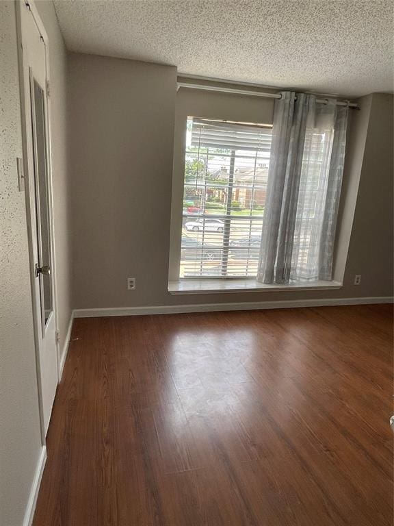 12400 Overbrook Ln Unit 45C, Houston, TX 77077 - empty room with a textured ceiling, wood finished floors, and baseboards