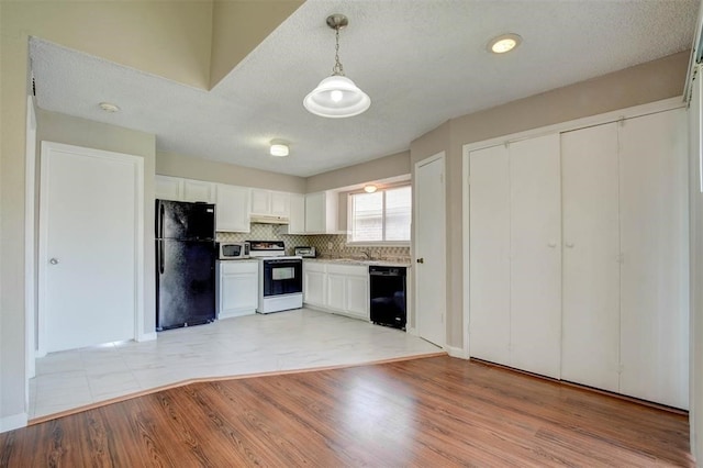 12400 Overbrook Ln Unit 45C, Houston, TX 77077 - kitchen with black appliances, white cabinets, a sink, light wood finished floors, and under cabinet range hood