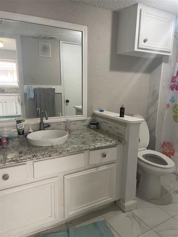 12400 Overbrook Ln Unit 45C, Houston, TX 77077 - bathroom featuring vanity, toilet, and marble look tiles