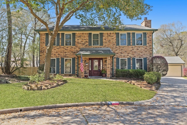 colonial inspired home featuring a front lawn, fence, a garage, brick siding, and a chimney