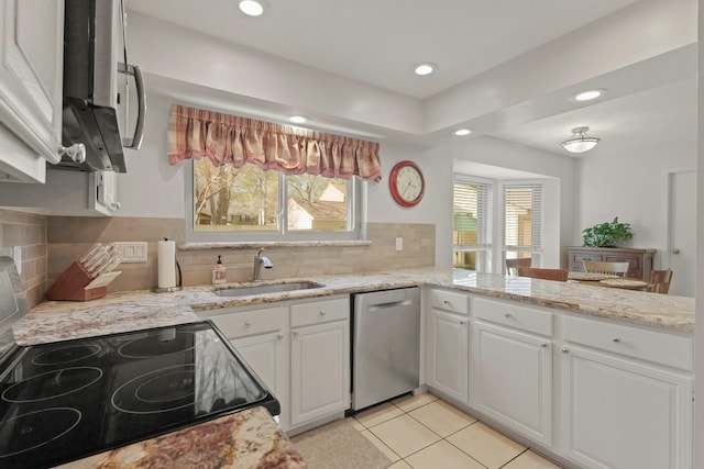 kitchen featuring dishwasher, white cabinets, a healthy amount of sunlight, and a sink