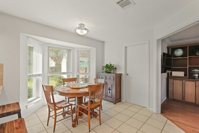 dining area with light tile patterned floors and visible vents