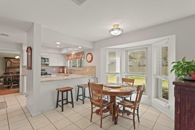 dining room featuring light tile patterned floors, visible vents, baseboards, and recessed lighting