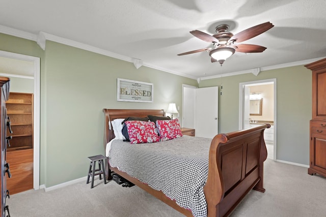 bedroom with ensuite bath, crown molding, baseboards, and light carpet