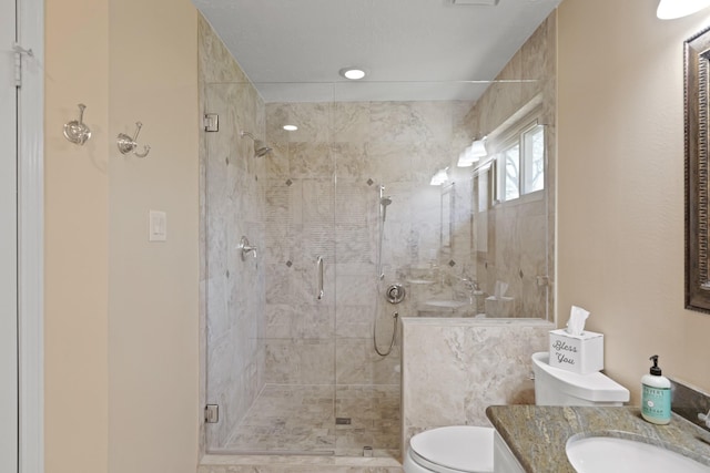 full bathroom featuring a stall shower, toilet, and vanity