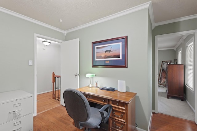 home office with crown molding, a textured ceiling, light wood-type flooring, and baseboards