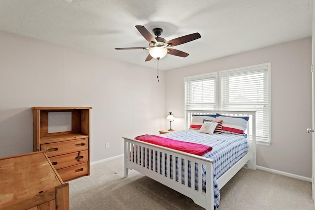 carpeted bedroom featuring baseboards and a ceiling fan