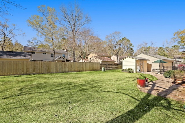 view of yard with a patio, an outdoor structure, and a fenced backyard