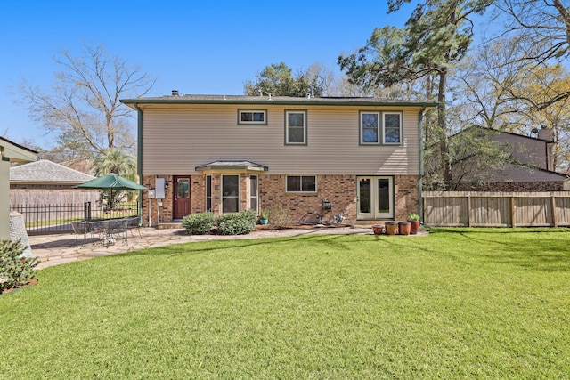 rear view of property with a patio, fence, brick siding, and a lawn