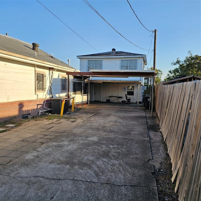 back of house with central AC unit and fence