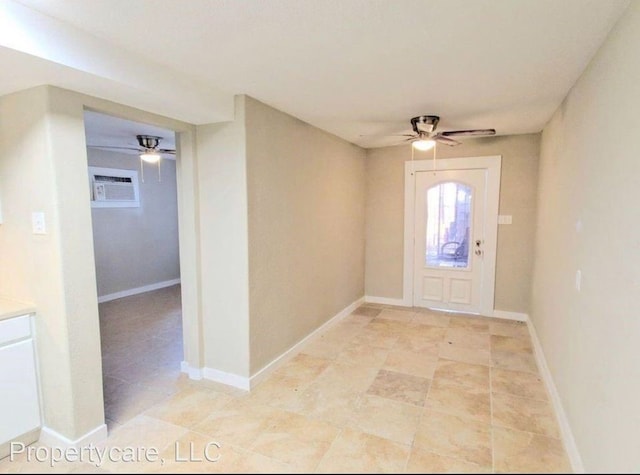 entrance foyer featuring ceiling fan, baseboards, and a wall unit AC