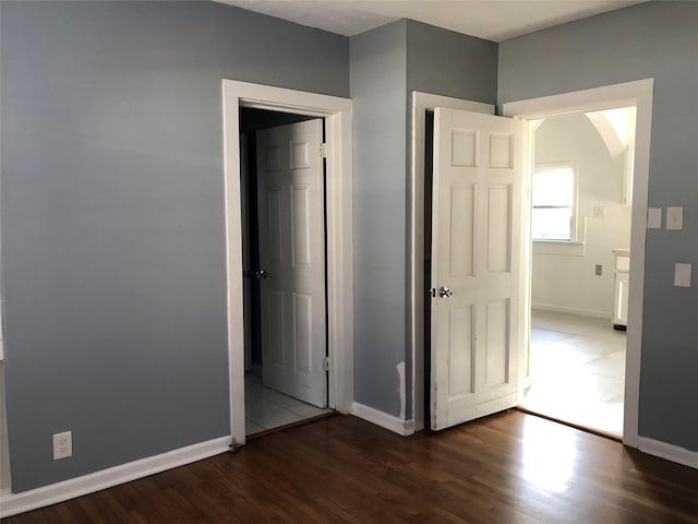 unfurnished bedroom featuring wood finished floors and baseboards