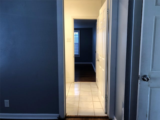 hall with light tile patterned floors and baseboards