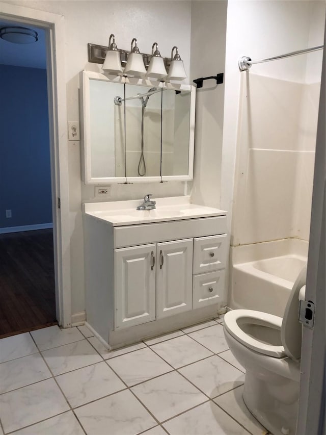 bathroom with toilet, marble finish floor, baseboards, bathing tub / shower combination, and vanity