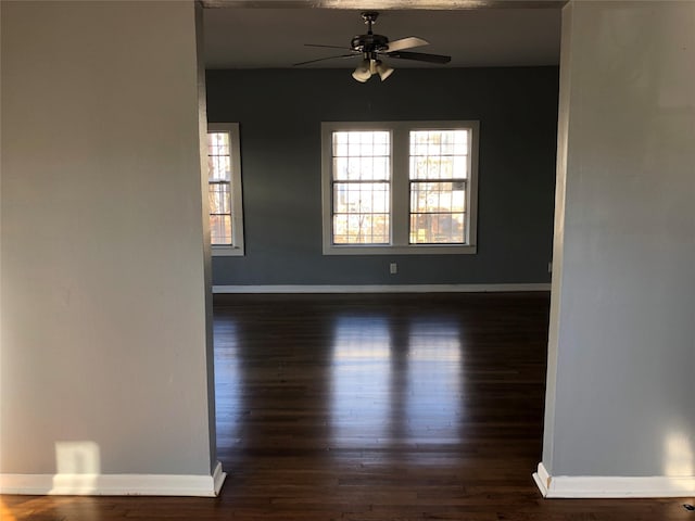 empty room featuring a ceiling fan, wood finished floors, and baseboards