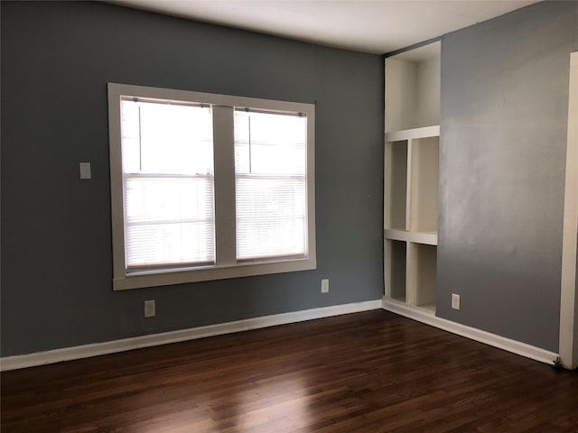 unfurnished room featuring baseboards and wood finished floors