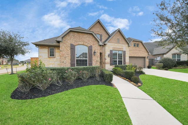 view of front of property featuring a front lawn, concrete driveway, stone siding, and an attached garage