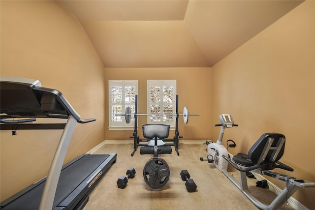 workout room featuring vaulted ceiling, carpet flooring, and baseboards