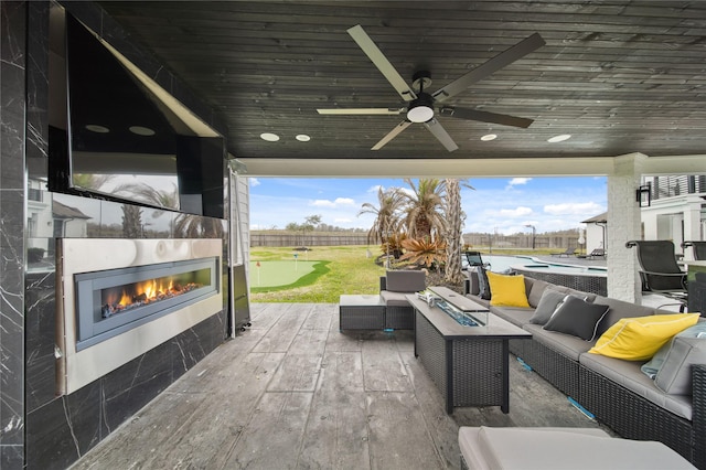 view of patio with an outdoor pool, a fenced backyard, a ceiling fan, and an outdoor living space with a fireplace