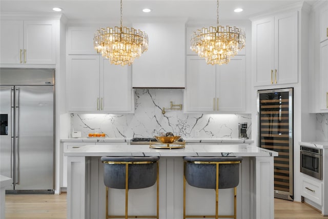 kitchen featuring stainless steel built in fridge, an inviting chandelier, beverage cooler, and decorative backsplash