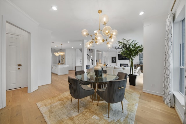 dining space featuring a notable chandelier, light wood-style floors, recessed lighting, and ornamental molding