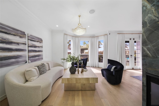 living area featuring recessed lighting, ornamental molding, french doors, and wood finished floors