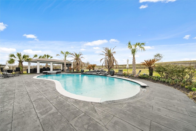 view of swimming pool with a gazebo, a pool with connected hot tub, a patio, and fence