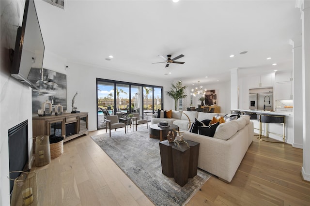 living room with visible vents, recessed lighting, a fireplace, and light wood-type flooring