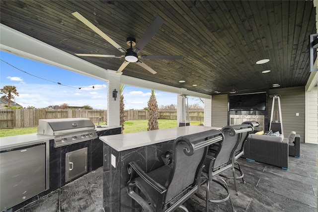 view of patio / terrace with ceiling fan, area for grilling, a fenced backyard, and an outdoor kitchen