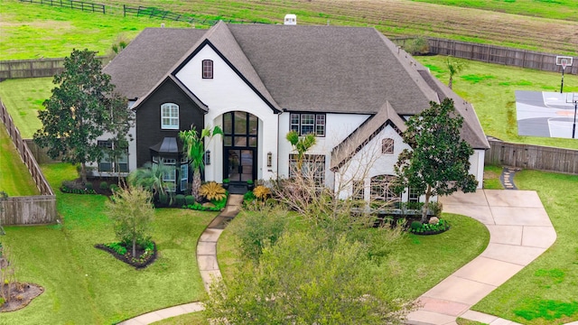 view of front facade with a front yard, fence private yard, driveway, and roof with shingles