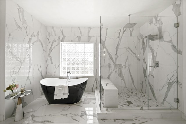 full bathroom featuring a marble finish shower, marble finish floor, stone wall, and a freestanding tub