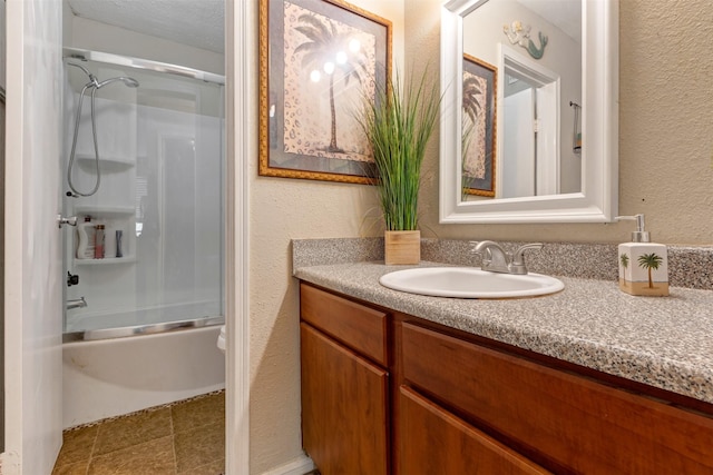 full bath with combined bath / shower with glass door, a textured ceiling, vanity, and a textured wall