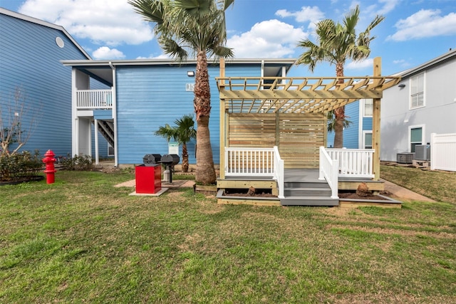 back of property with cooling unit, a lawn, a pergola, and a wooden deck