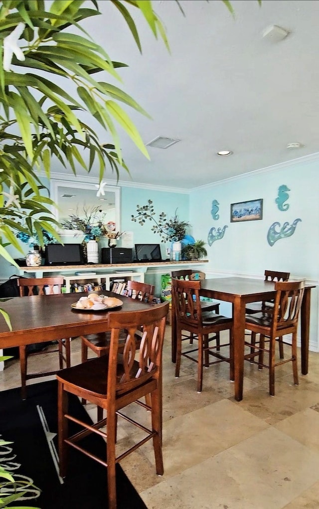 dining space featuring visible vents and ornamental molding