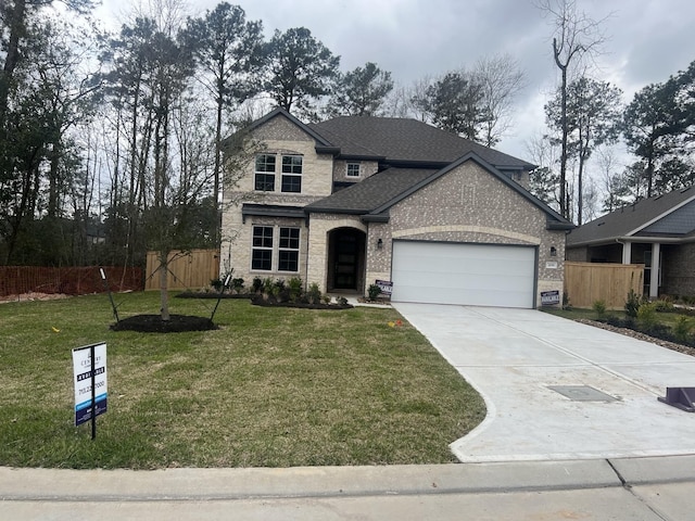 view of front of property featuring brick siding, a garage, a front lawn, and fence