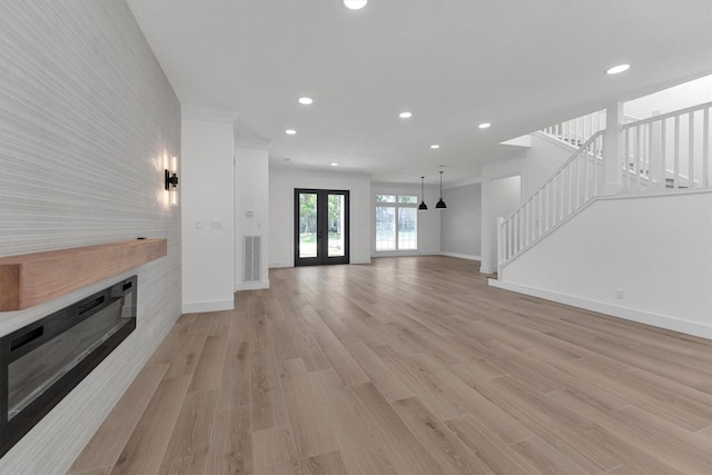 living room with visible vents, baseboards, recessed lighting, light wood-style floors, and french doors