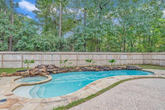 view of pool featuring a patio area, a pool with connected hot tub, and a fenced backyard