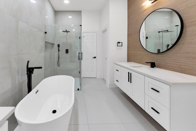 full bathroom with tile patterned floors, vanity, tile walls, and a shower stall