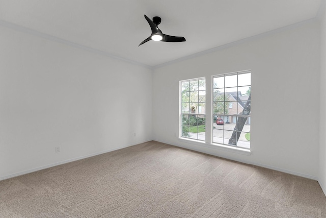 spare room with baseboards, light colored carpet, ceiling fan, and ornamental molding