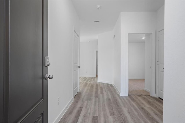 hallway featuring baseboards and wood finished floors