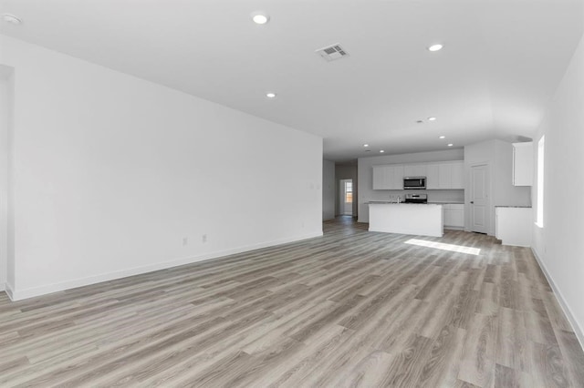 unfurnished living room with light wood-style flooring, recessed lighting, visible vents, and baseboards