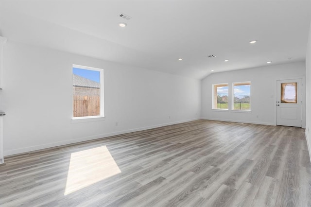 unfurnished living room with visible vents, baseboards, lofted ceiling, recessed lighting, and light wood-style floors