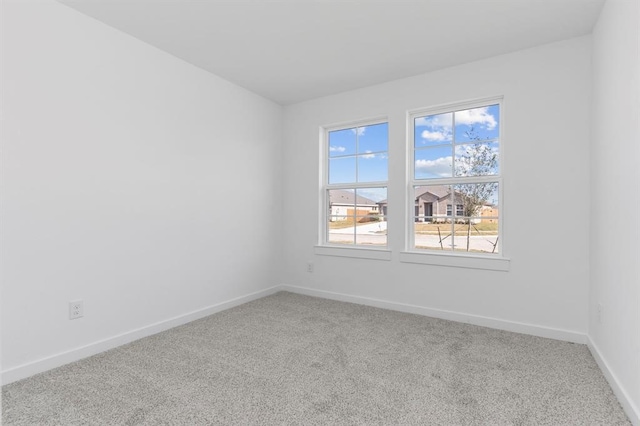 carpeted empty room featuring baseboards