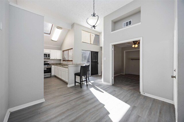 kitchen with visible vents, light wood-type flooring, appliances with stainless steel finishes, white cabinets, and a sink