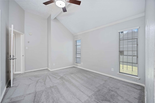 carpeted spare room featuring ornamental molding, a textured ceiling, baseboards, ceiling fan, and vaulted ceiling