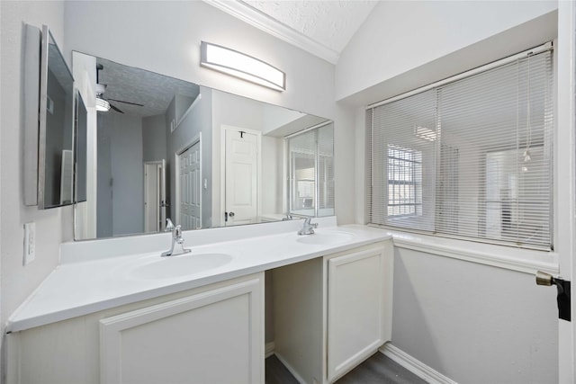 bathroom featuring a textured ceiling, double vanity, ceiling fan, and a sink